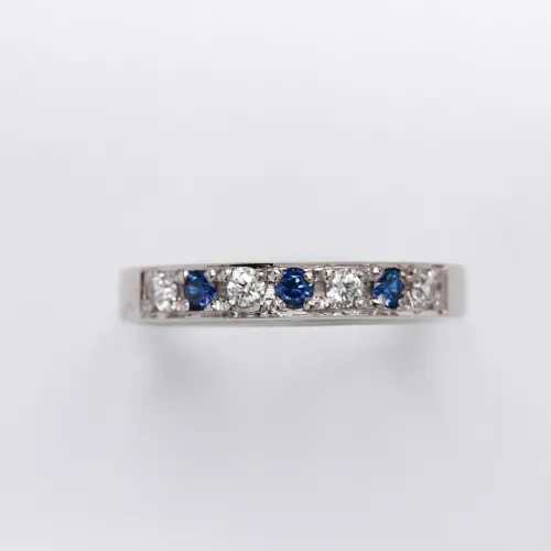 anillo de compromiso de oro 18k blanco medio sin fin con diamantes y zafiros sobre fondo blanco
