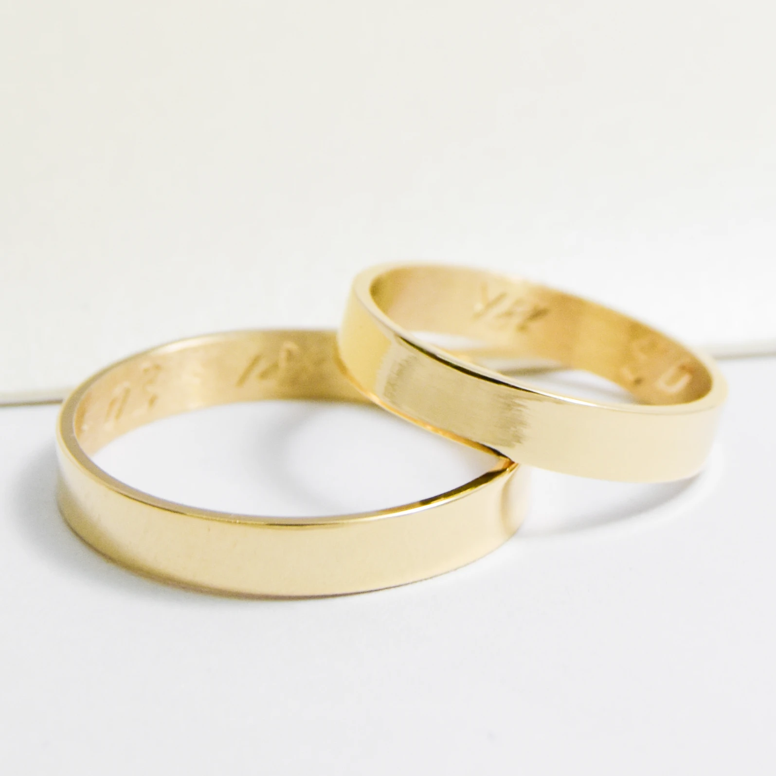 Alianzas de casamiento de oro 18K amarillo modelo Cinta sobre fondo blanco