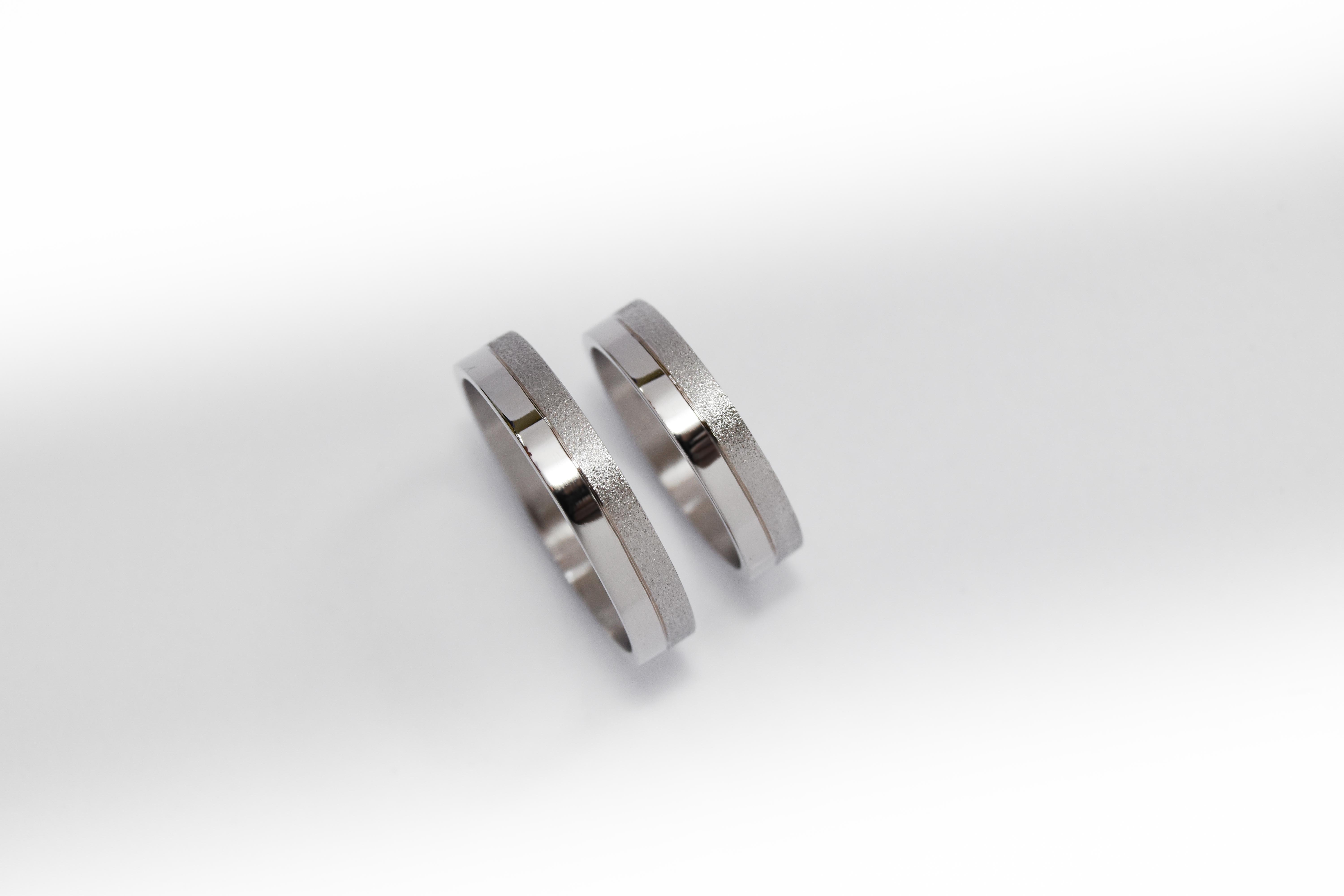 Alianzas de oro 18k blanco con textura satinado sobre fondo blanco