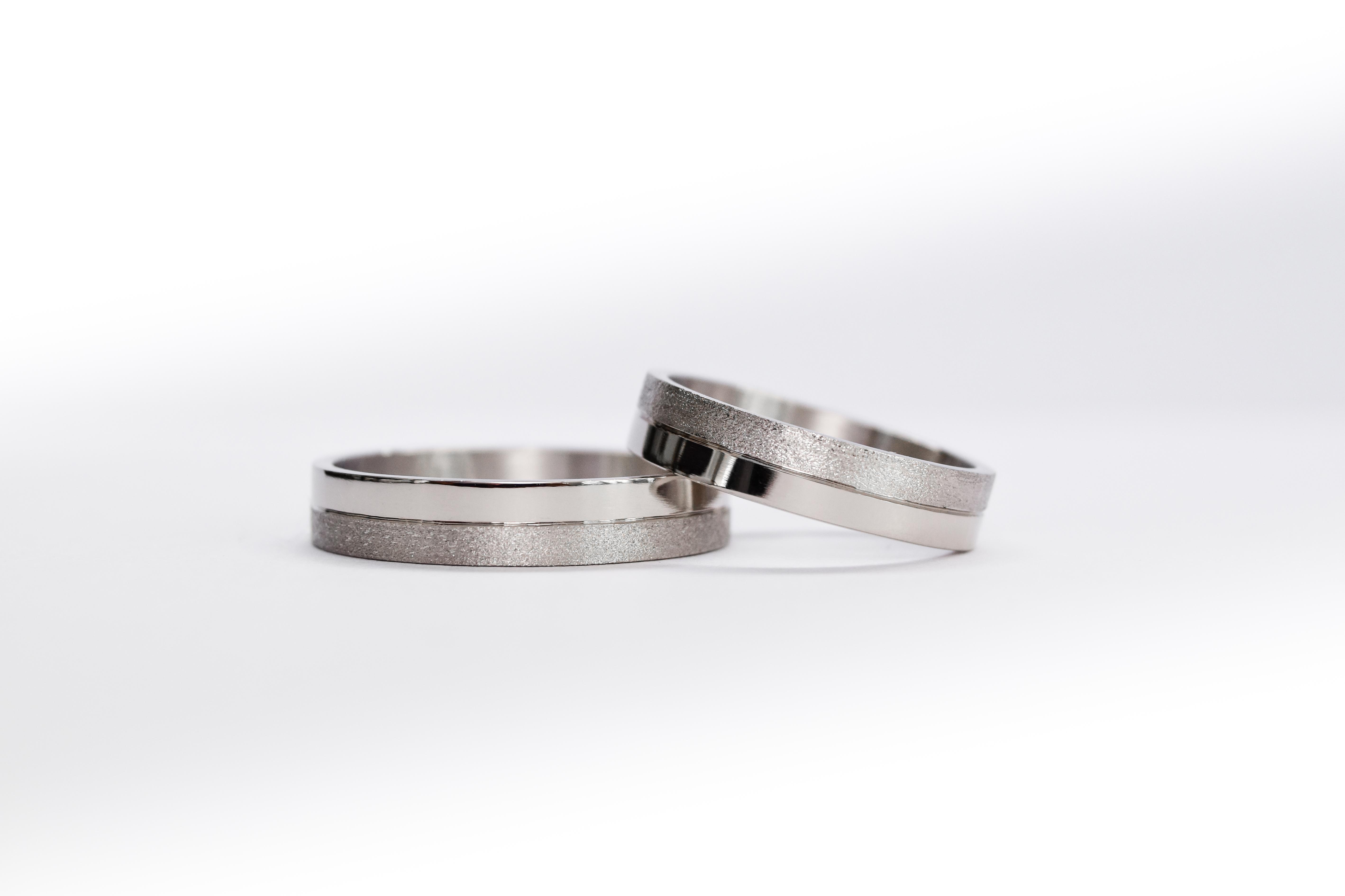 Alianzas de oro 18k blanco con textura satinado sobre fondo blanco