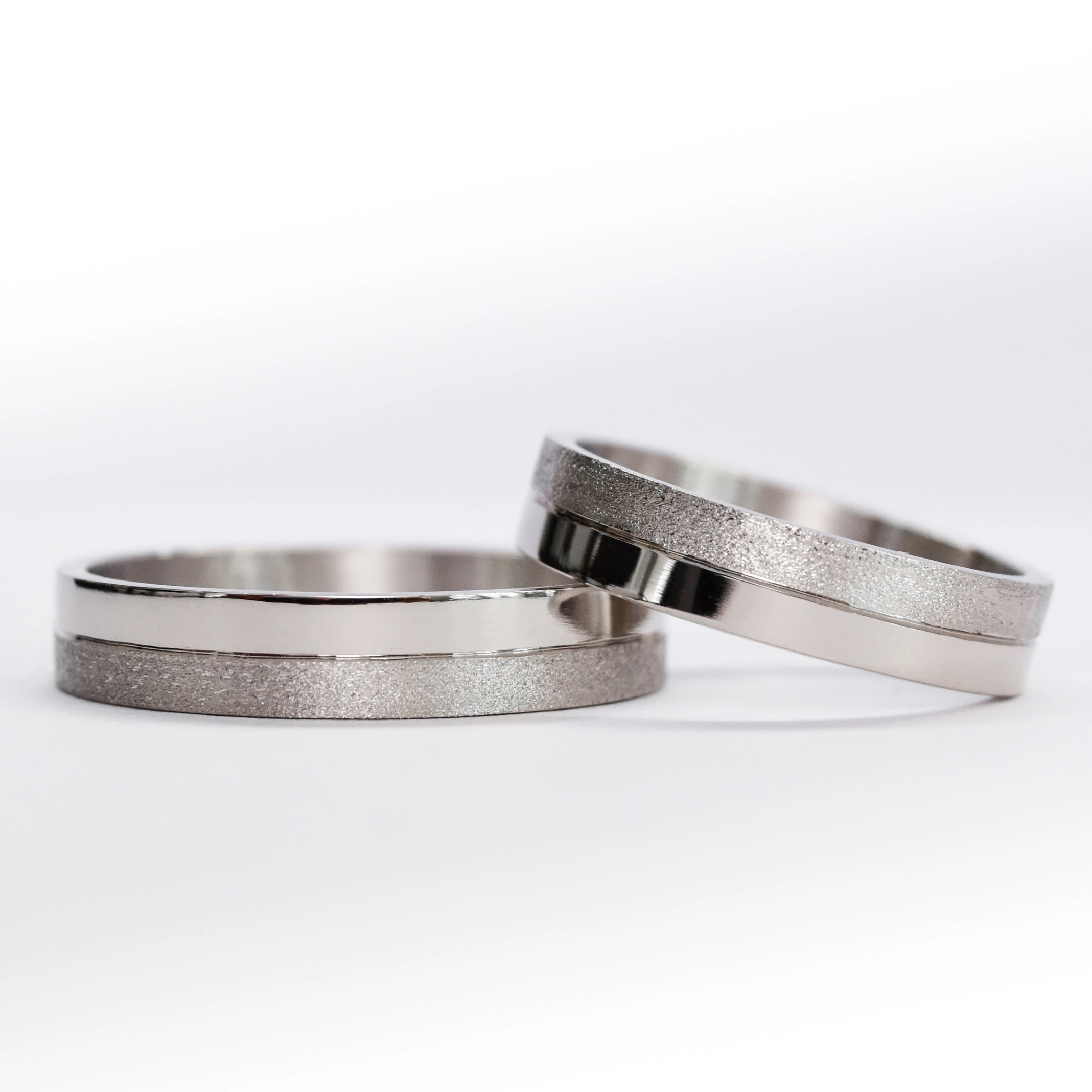 Alianzas de oro 18k blanco con textura satinado sobre fondo blanco