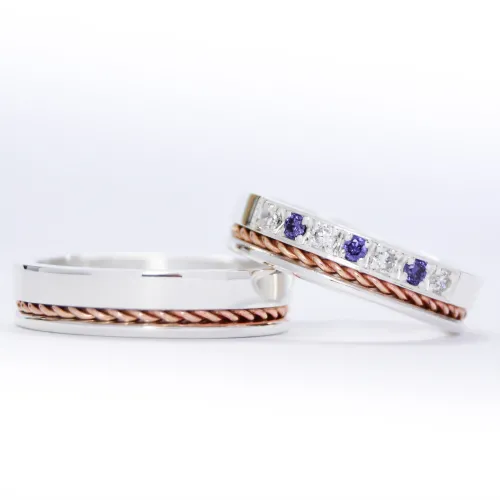 Alianzas de plata 950k y oro 18k rosa con diamantes blancos y amatistas engarzadas. sobre fondo blanco.