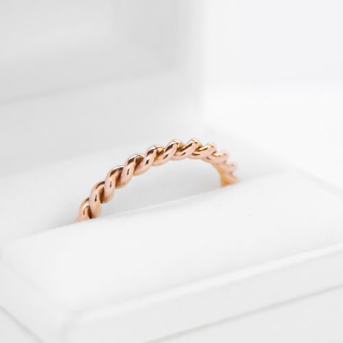 Anillo de oro 18k rosa tipo trenza sobre fondo blanco
