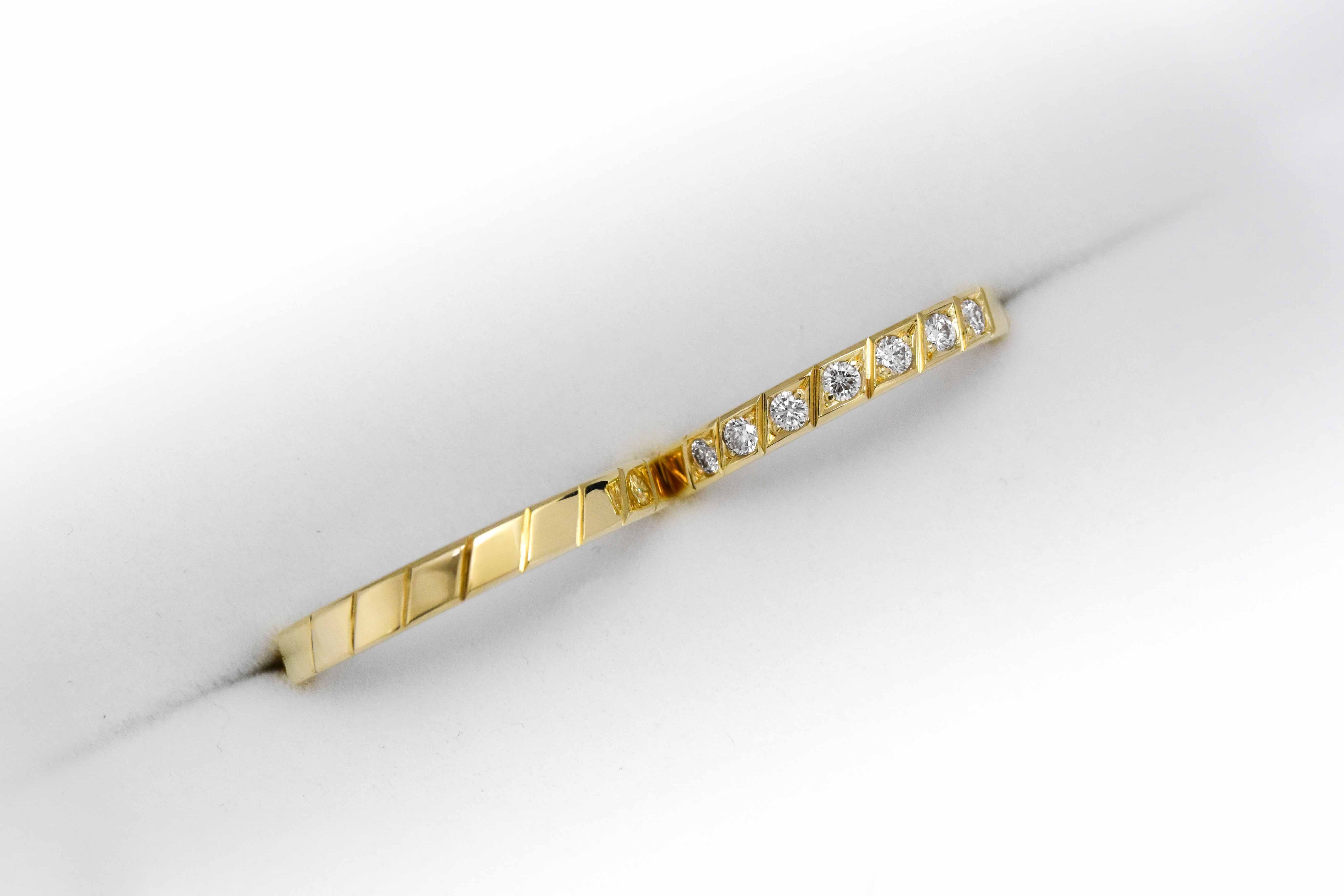 Alianzas de oro 18k amarillo con diamantes blancos engarzadas a mano sobre fondo blanco