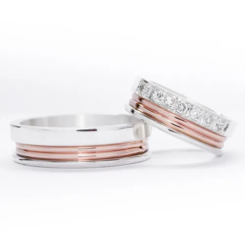 Alianzas de plata 950k y oro 18k rosa con diamantes blanco engarzadas. sobre fondo blanco.