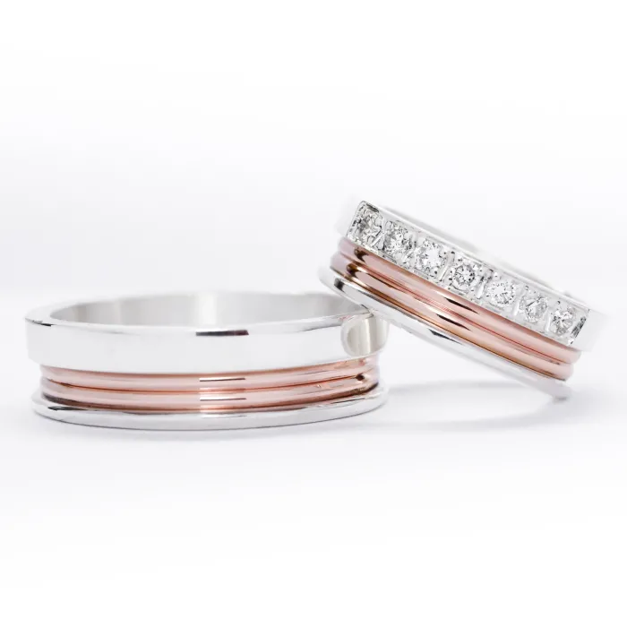 Alianzas de plata 950k y oro 18k rosa con diamantes blanco engarzadas. sobre fondo blanco.