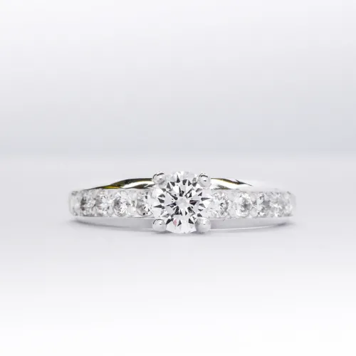 Anillo de compromiso de plata 925k con una gema blanca brillante y otras a los costados sobre fondo blanco