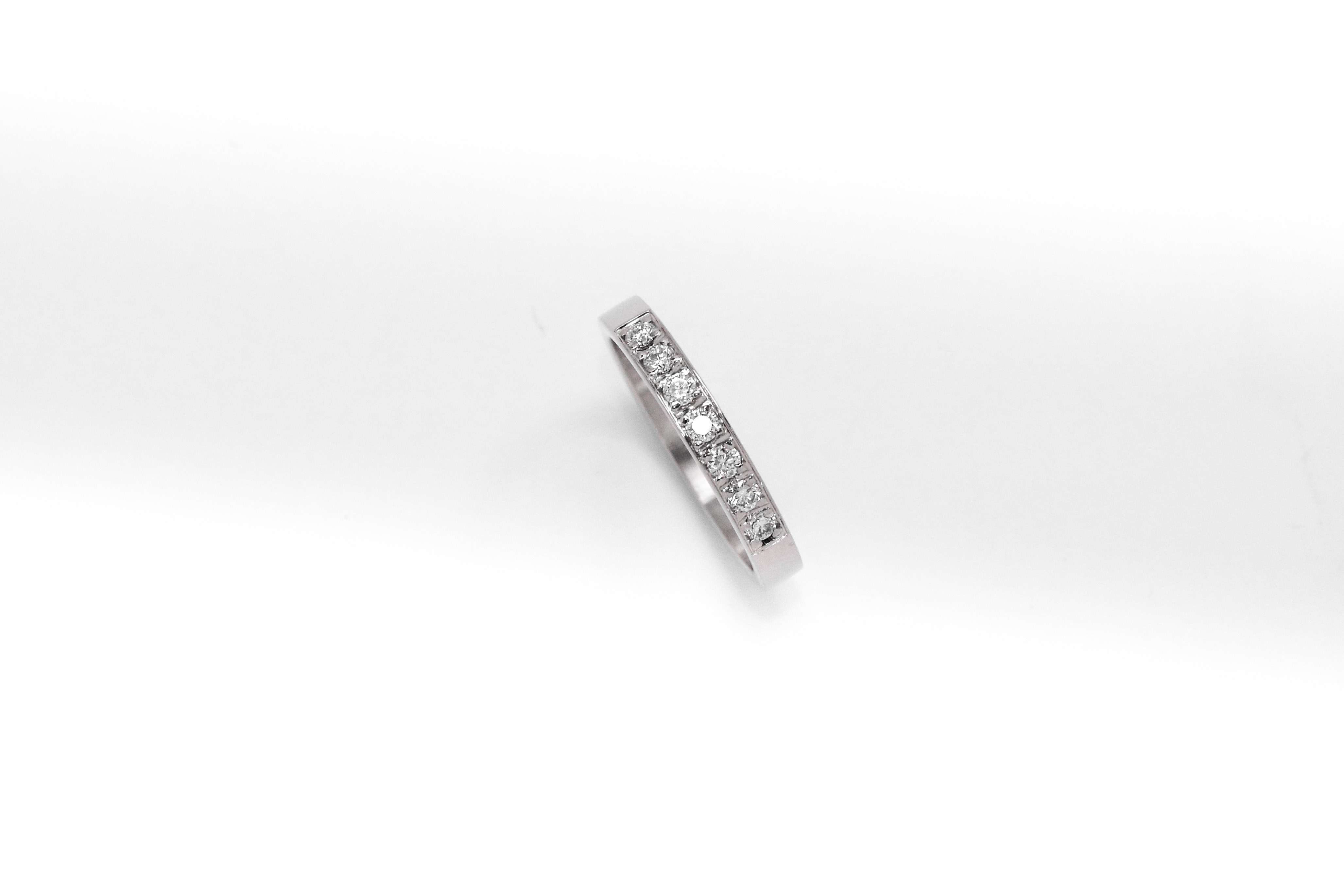 anillo de compromiso de oro 18k blanco medio sin fin con diamantes sobre fondo blanco