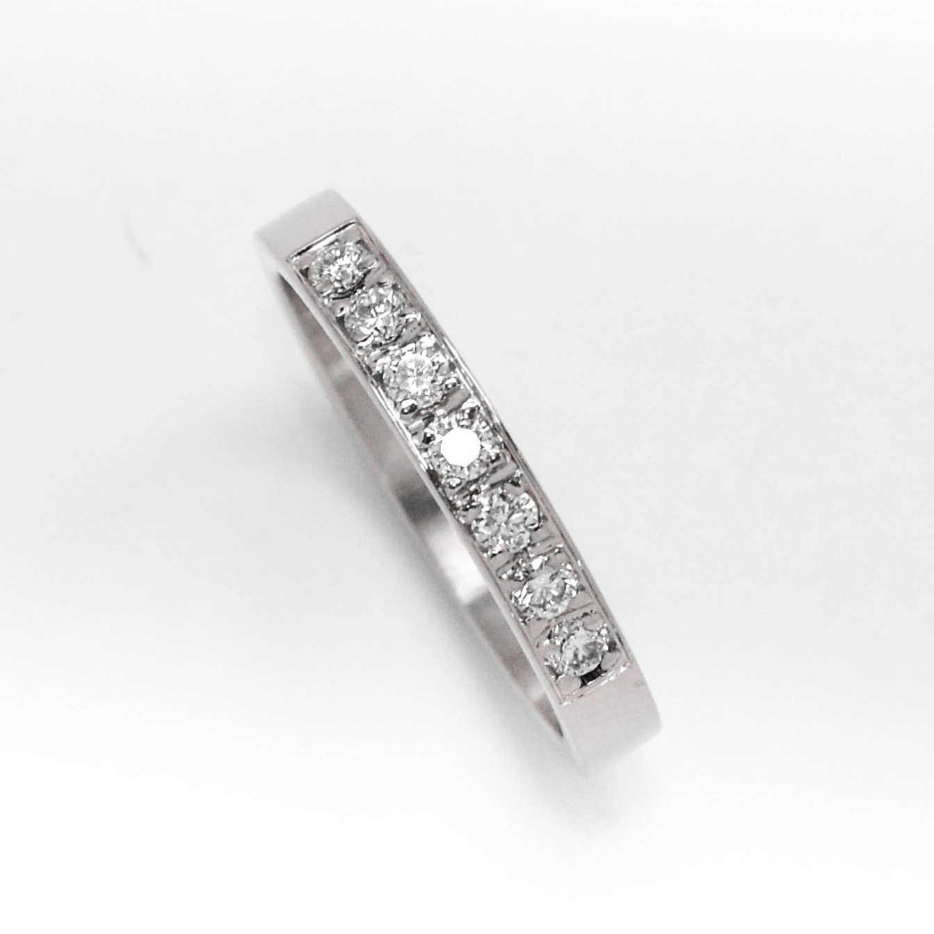 anillo de compromiso de oro 18k blanco medio sin fin con diamantes sobre fondo blanco
