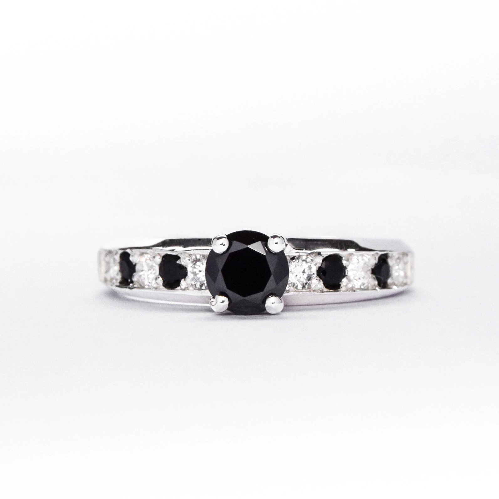 Anillo de compromiso de plata 925k con gemas blancas y negras sobre fondo blanco