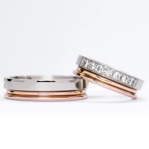 Alianzas de oro 18k blanco y rosa con diamantes blancas engarzadas. sobre fondo blanco.