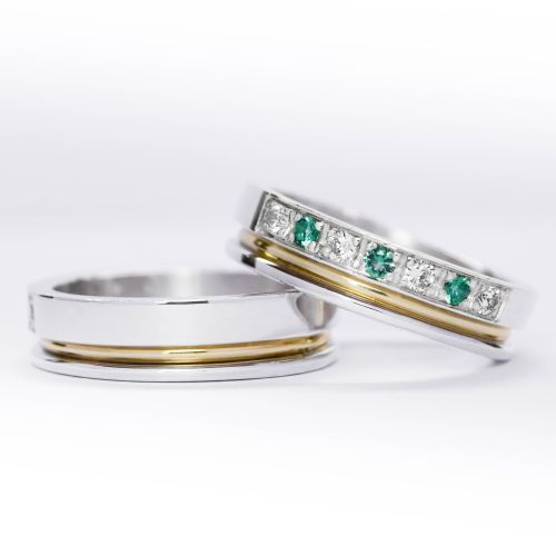 Alianzas de plata 950k y oro 18k amarillo con diamantes blancos y esmeraldas engarzadas. sobre fondo blanco.