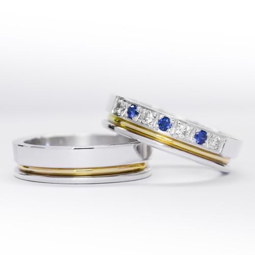 Alianzas de plata 950k y oro 18k amarillo con diamantes blancos y zafiros engarzadas. sobre fondo blanco.