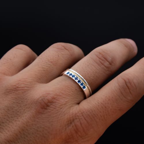 Anillo de hombre de plata 950k y oro 18k amarillo con trenza y gemas azules engarzadas a mano sobre fondo negro