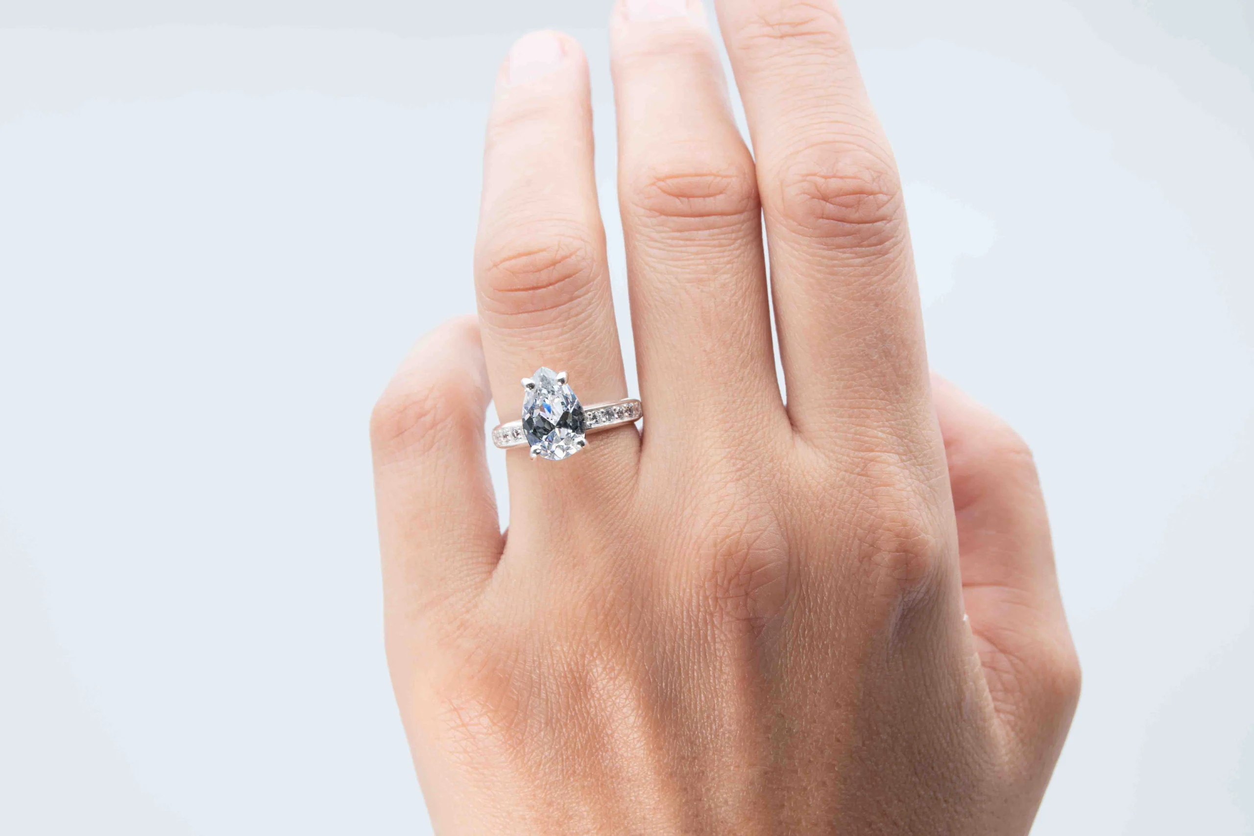 Anillo de plata con una gema Pear Cut sobre el dedo