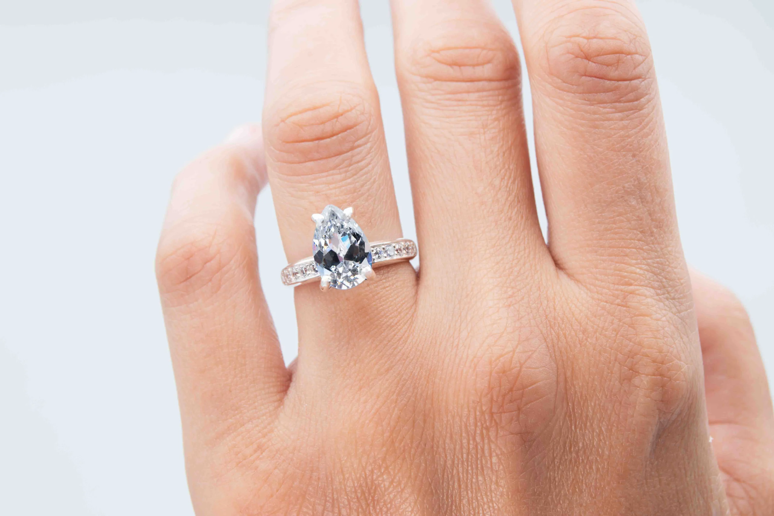Anillo de plata con una gema Pear Cut sobre el dedo