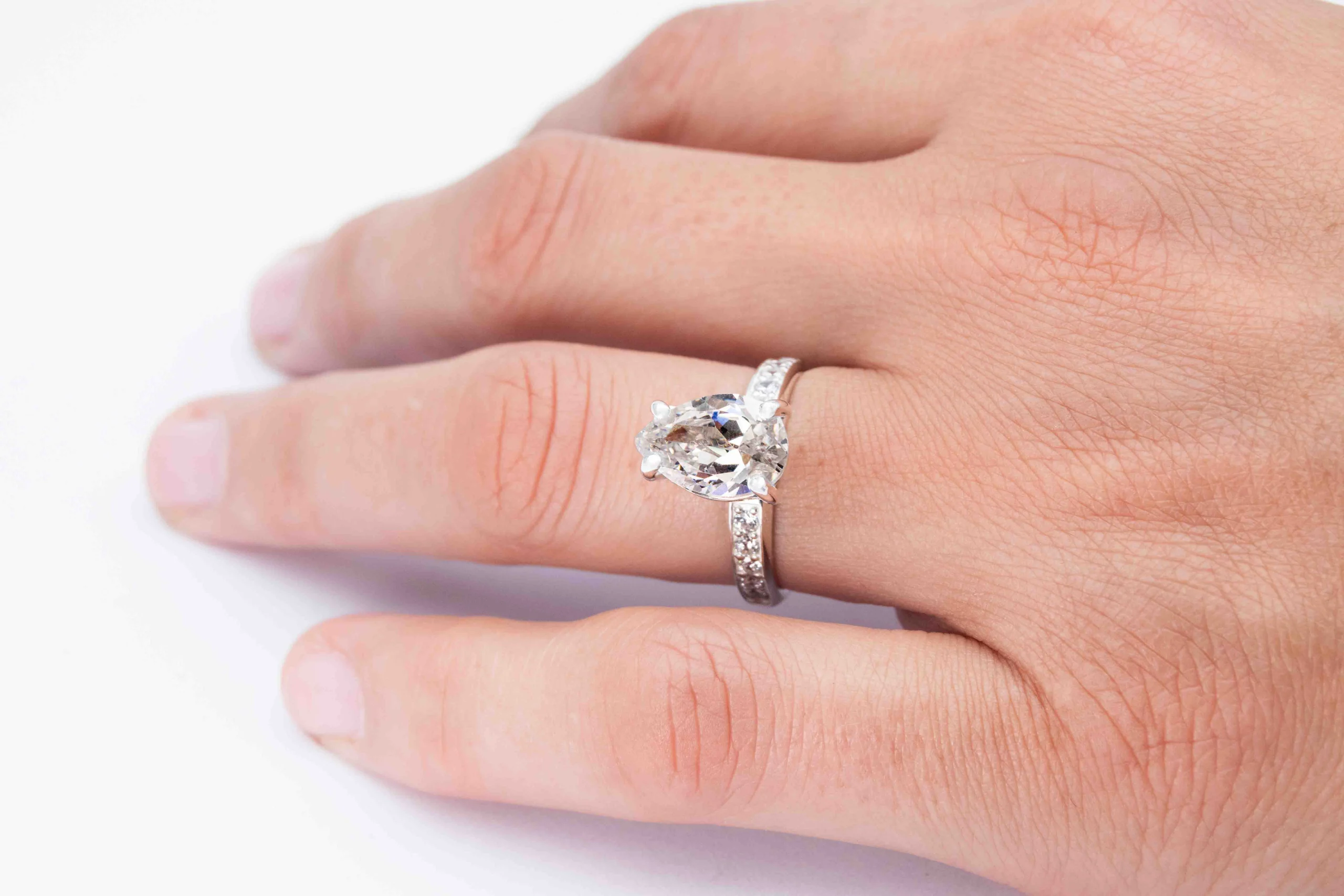 Anillo de plata con una gema Pear Cut sobre el dedo