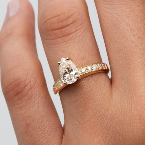 anillo de compromiso de oro modelo Taylor con gema pear cut en la mano de la modelo