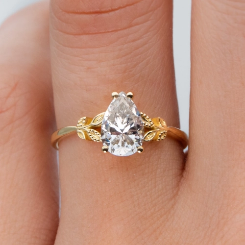 anillo de compromiso de oro modelo Taylor con gema pear cut en la mano de la modelo