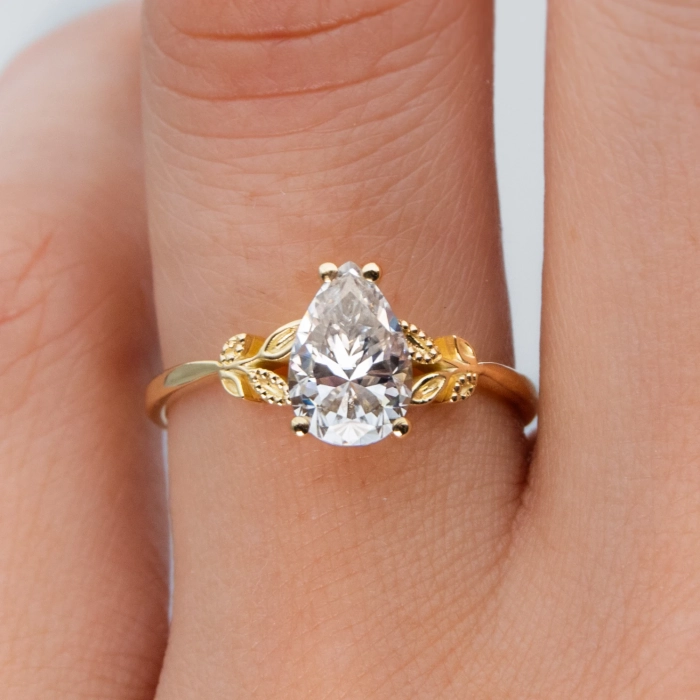 anillo de compromiso de oro modelo Taylor con gema pear cut en la mano de la modelo