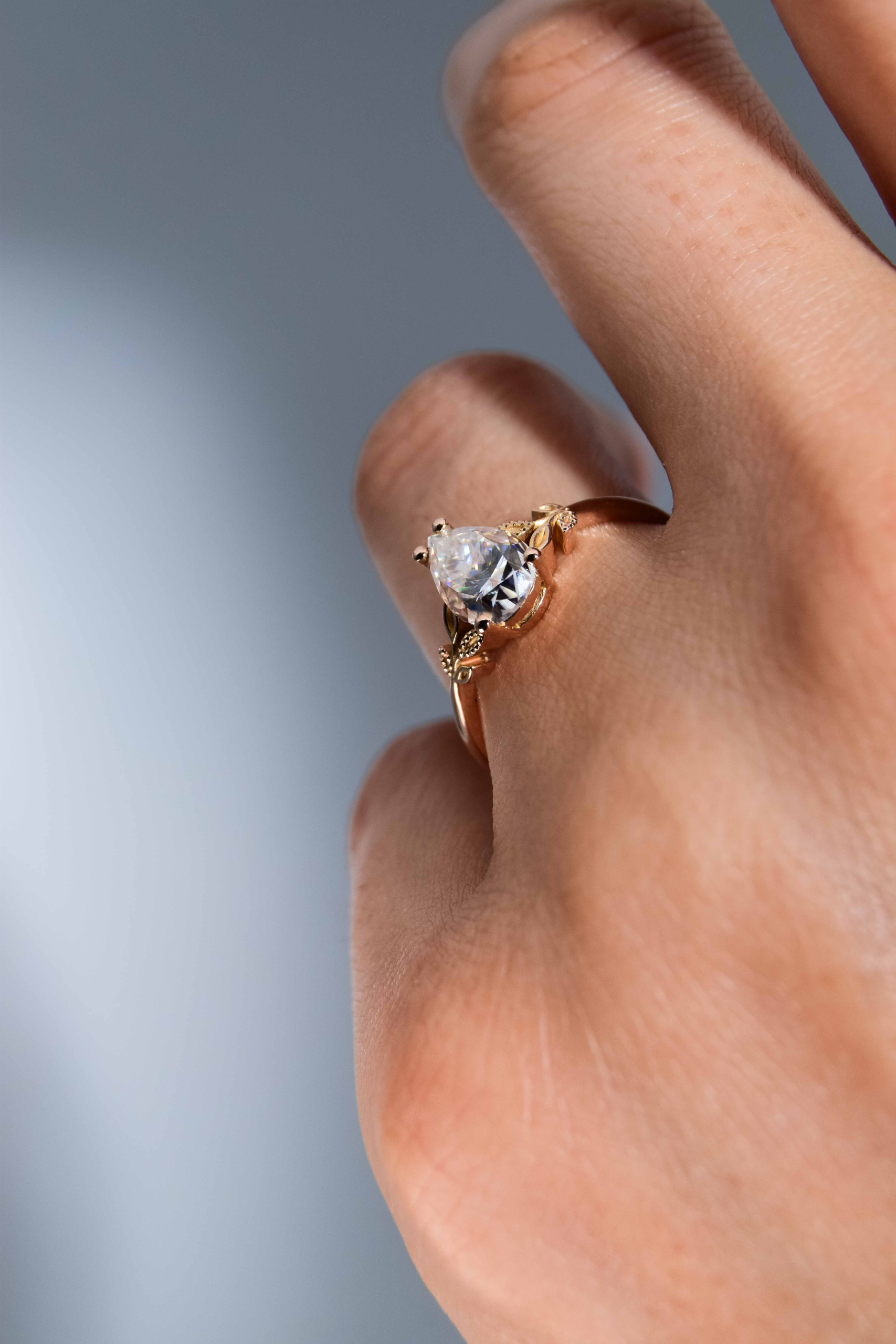 anillo de compromiso de oro modelo Taylor con gema pear cut en la mano de la modelo