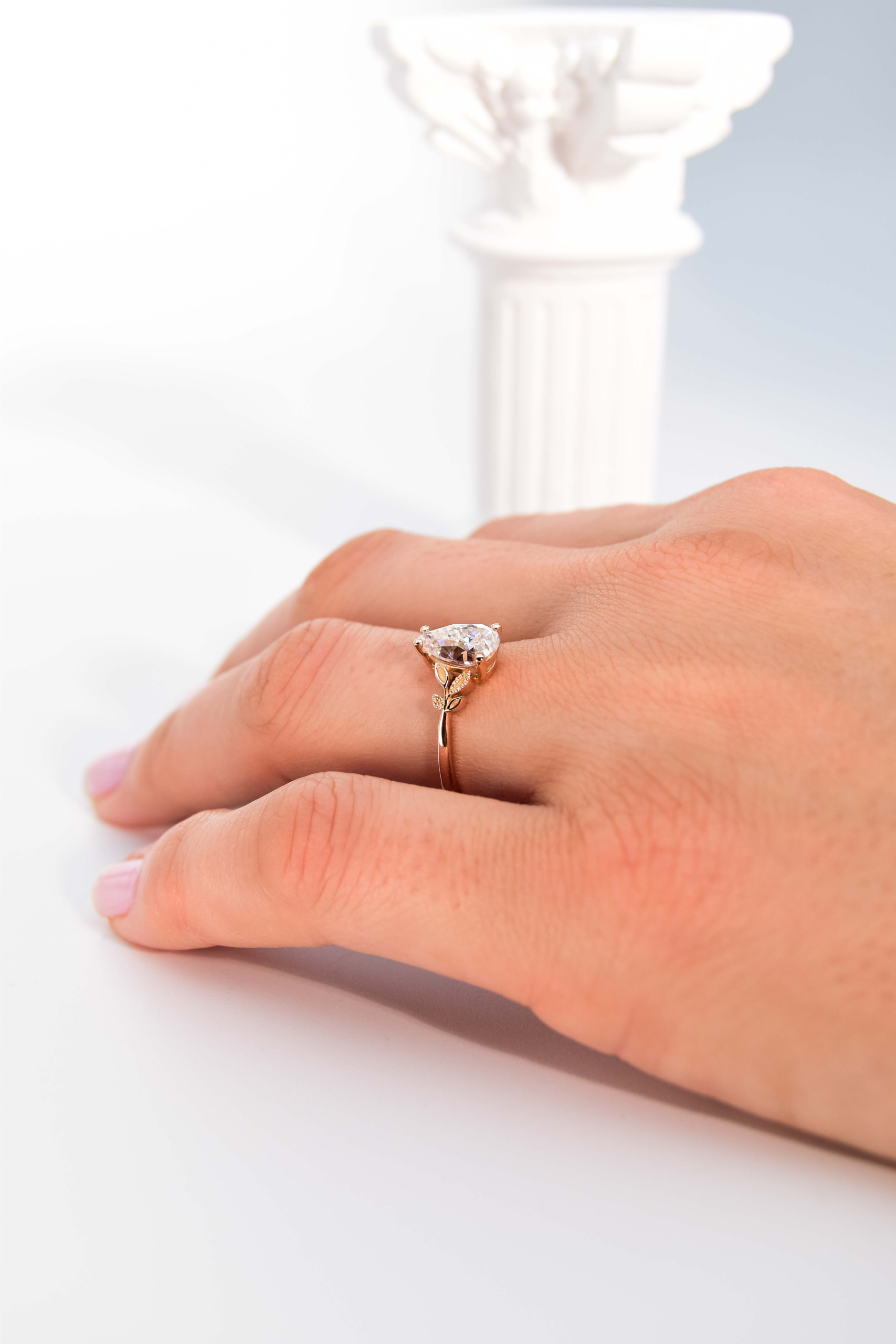 anillo de compromiso de oro modelo Taylor con gema pear cut en la mano de la modelo