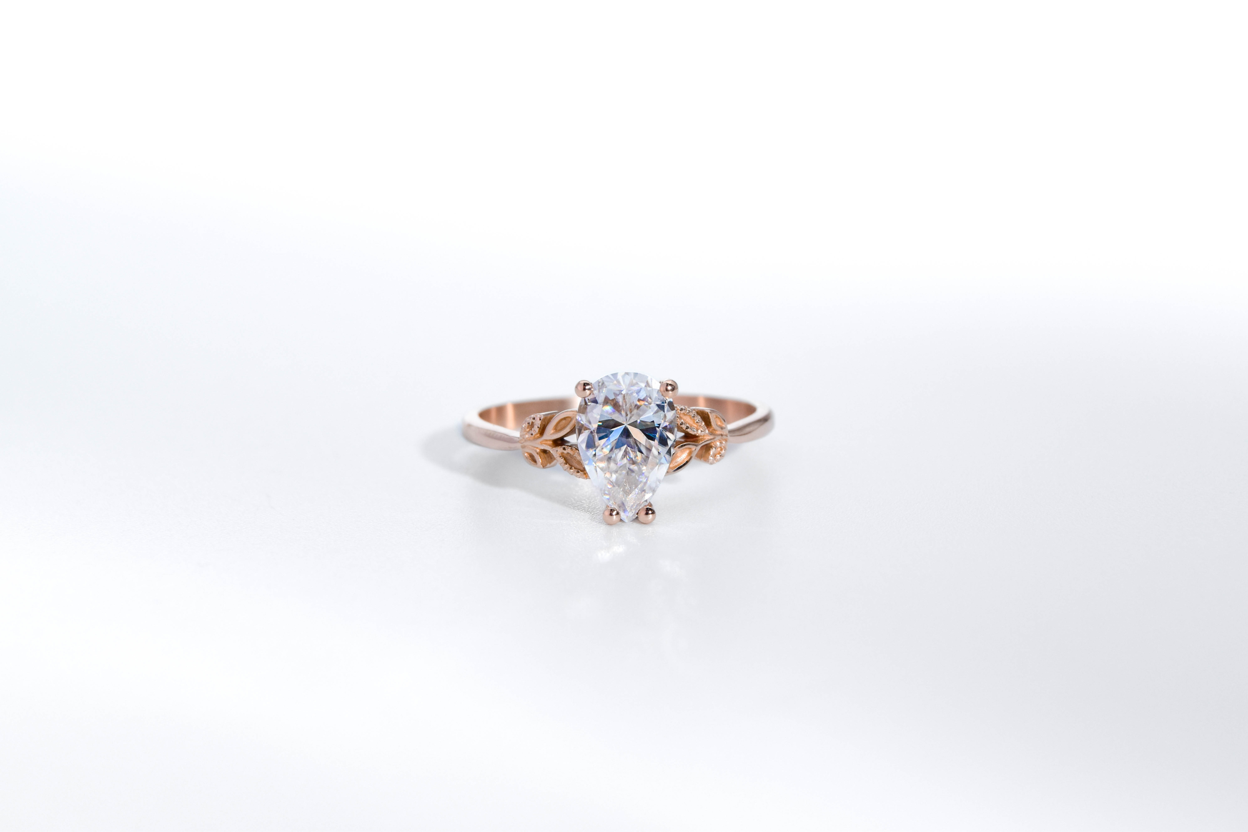anillo de compromiso de oro modelo Olivia con gema pear cut sobre fondo blanco