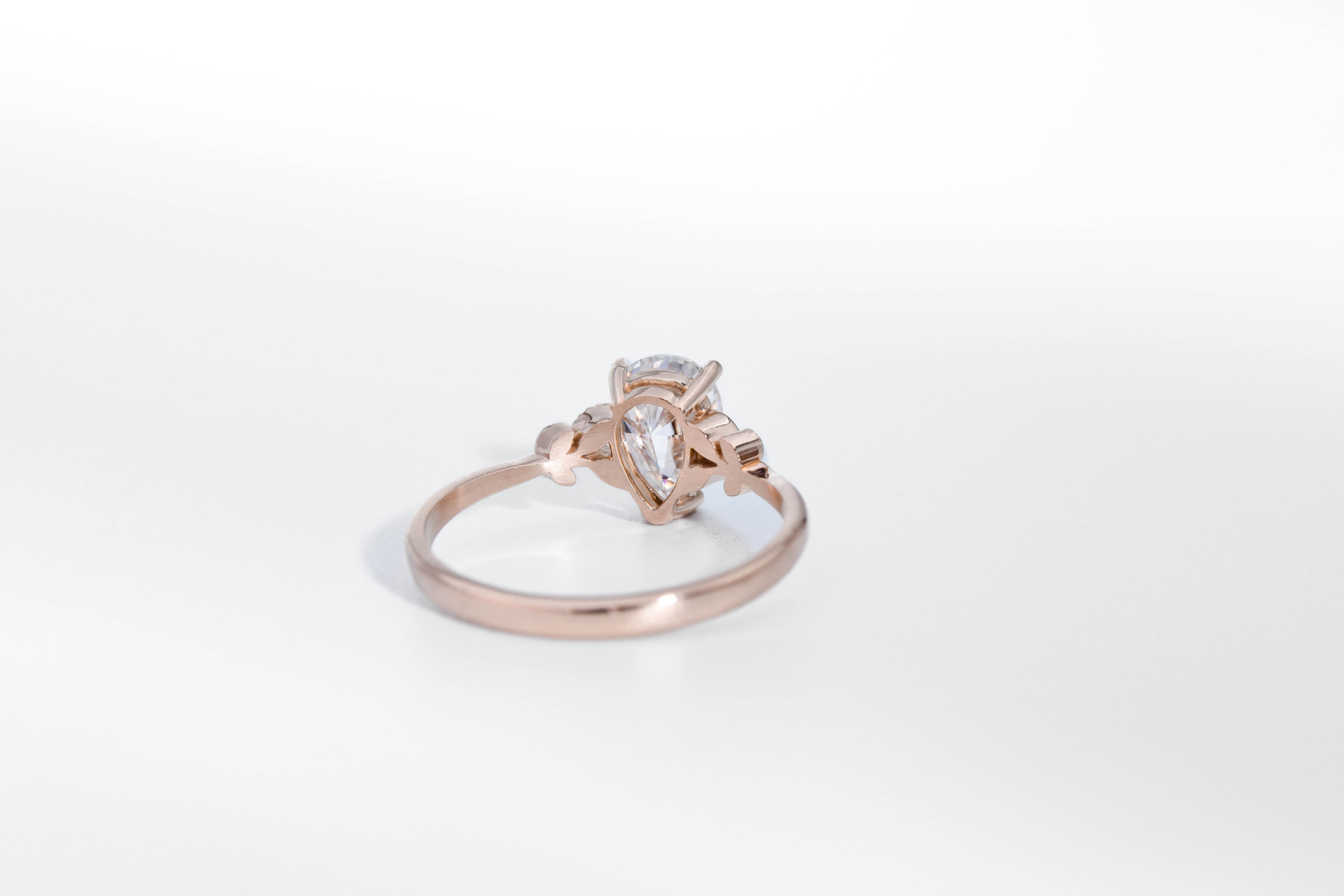 anillo de compromiso de oro modelo Olivia con gema pear cut sobre fondo blanco