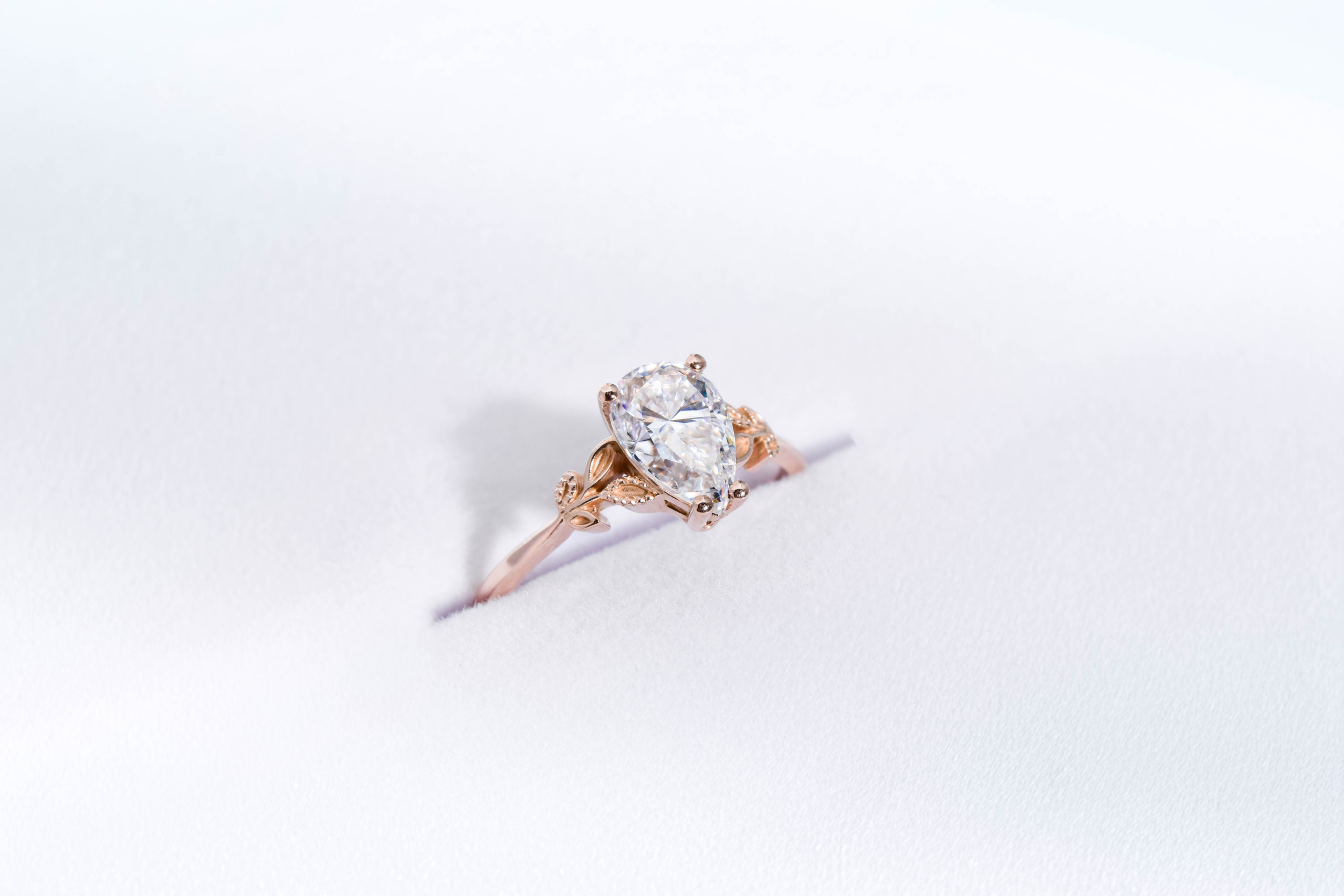 anillo de compromiso de oro modelo Olivia con gema pear cut sobre fondo blanco