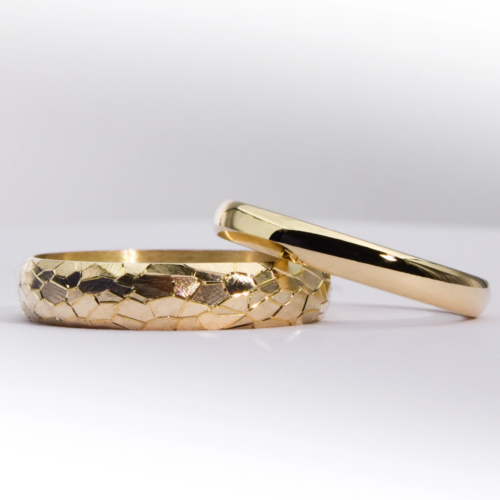 Alianzas de casamiento de oro 18K con textura de diferentes anchos modelo Perseo sobre fondo blanco