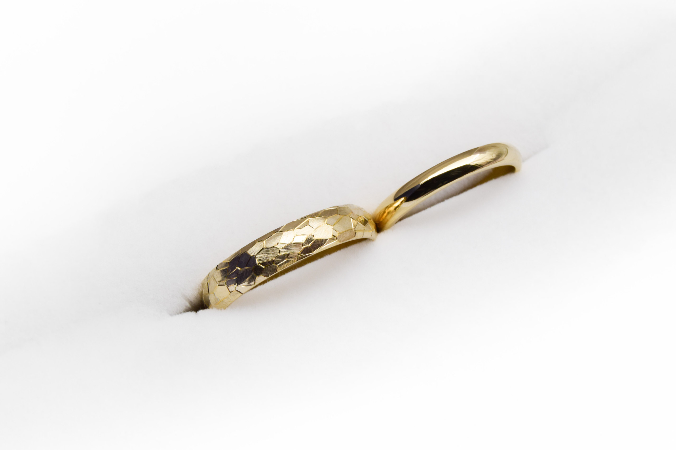 Alianzas de casamiento de oro 18K con textura de diferentes anchos modelo Perseo sobre fondo blanco