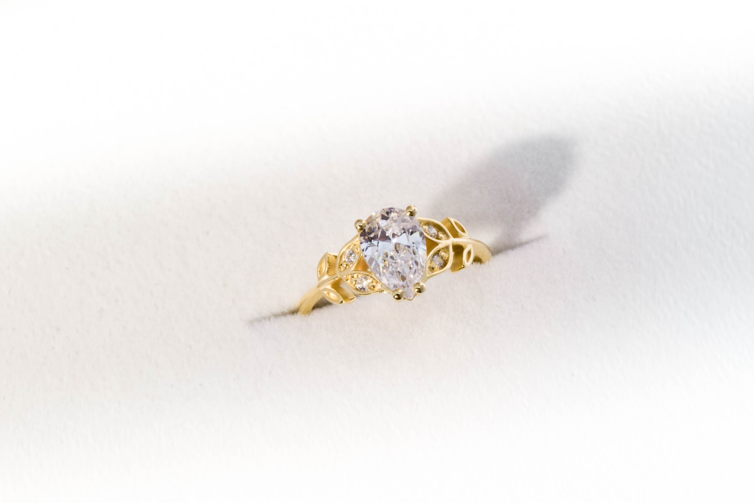 anillo de compromiso de oro modelo Olivia N2 con gema pear cut sobre fondo blanco