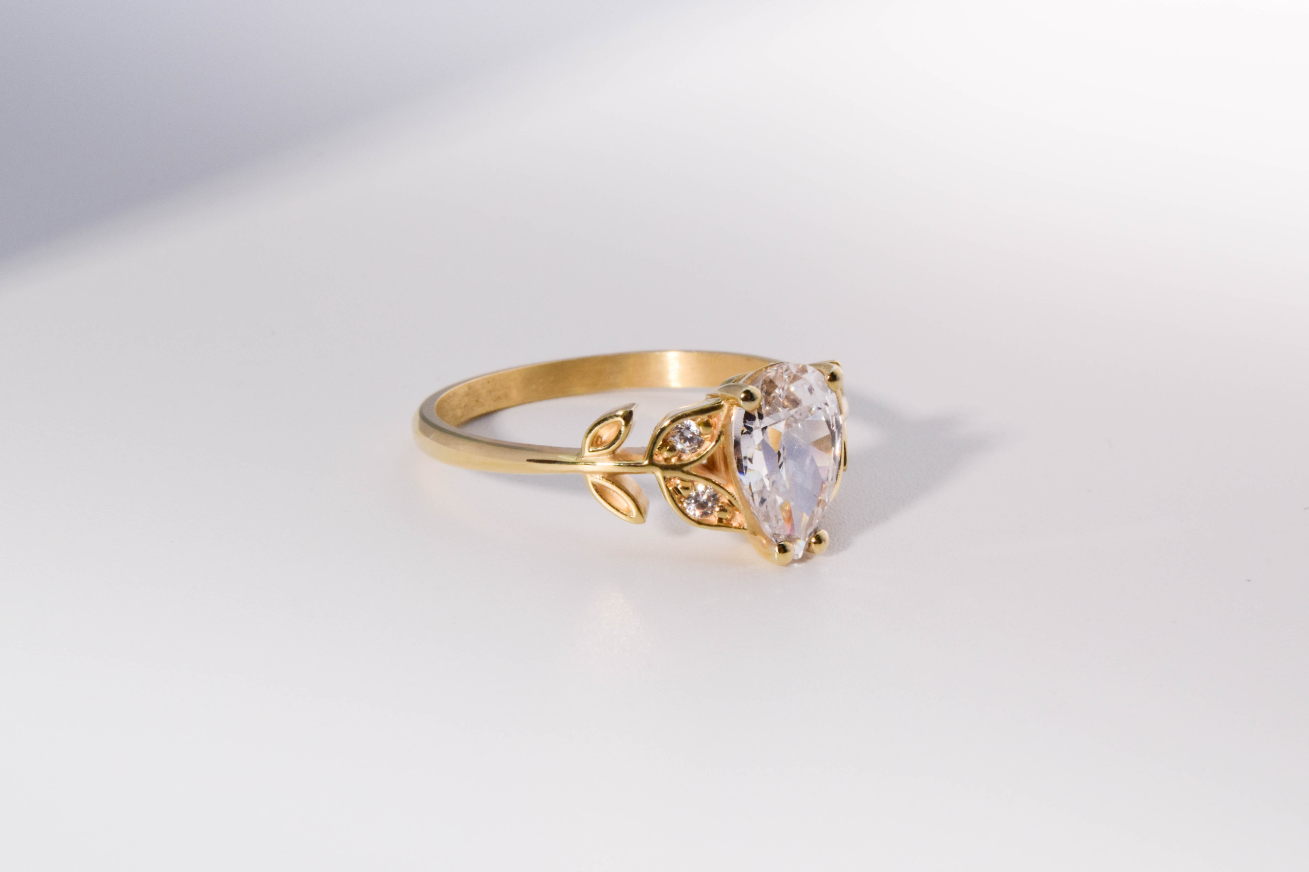 anillo de compromiso de oro modelo Olivia N2 con gema pear cut sobre fondo blanco
